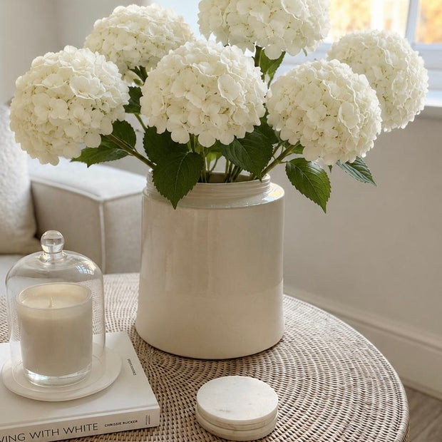 Round Marble Coasters - Set of Four, round marble coasters on a woven table beside flowers