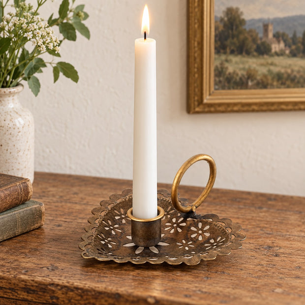 Heart Shaped Metal Candle Holder, brass-coloured heart holder with a lit taper on a wooden table