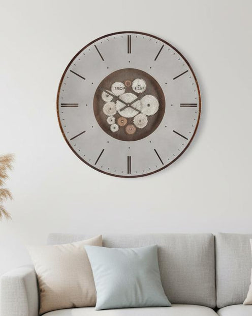 Thomas Kent 21" Clocksmith Wall Clock Cog Bronze, round bronze and cream clock above a pale sofa