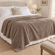 Beige Luxury Snuggle Blanket Throw, beige throw spread across a neutral bed