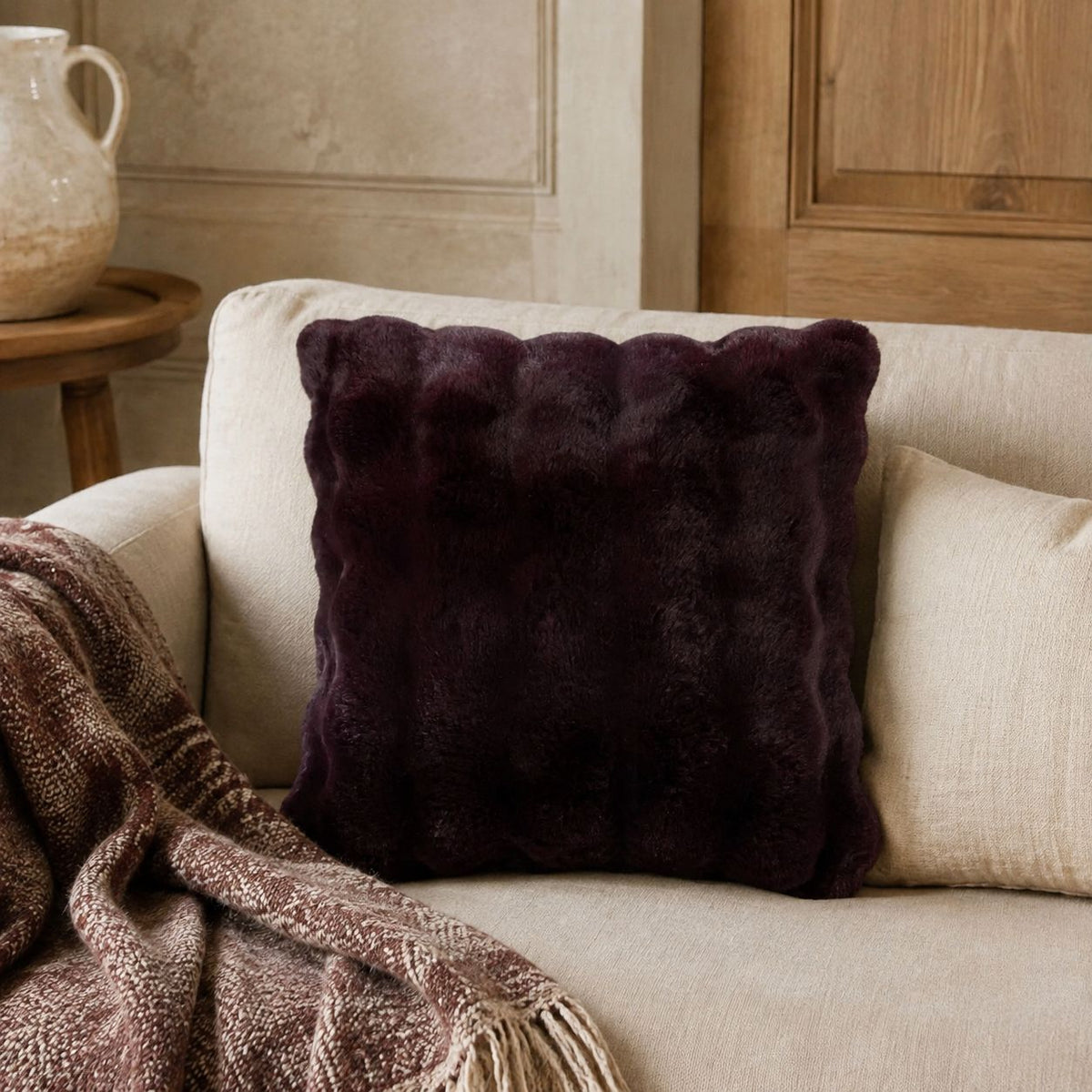 Burgundy Luxury Faux Fur Cushion, burgundy faux fur cushion beside a brown throw on a sofa