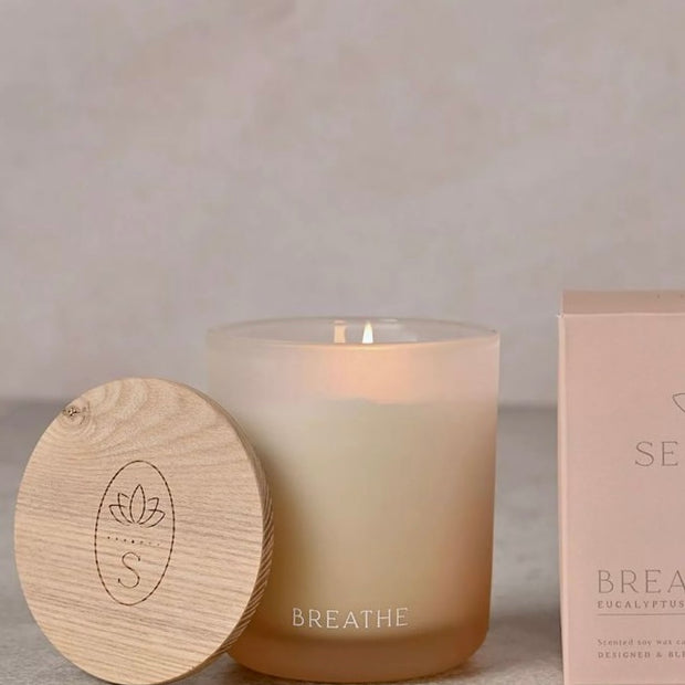 Serenity Breathe Candle 270g Eucalyptus Sage & Vetiver, cream candle in a peach-toned glass jar beside its wooden lid and box