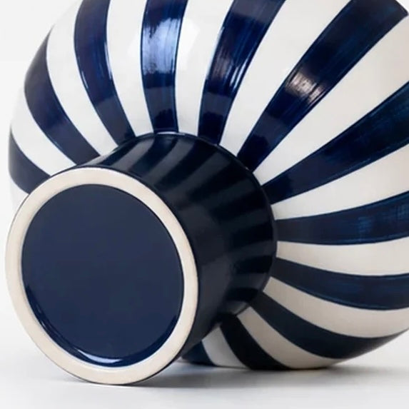 Underside of the blue pedestal foot and striped ceramic body of the decorative bowl