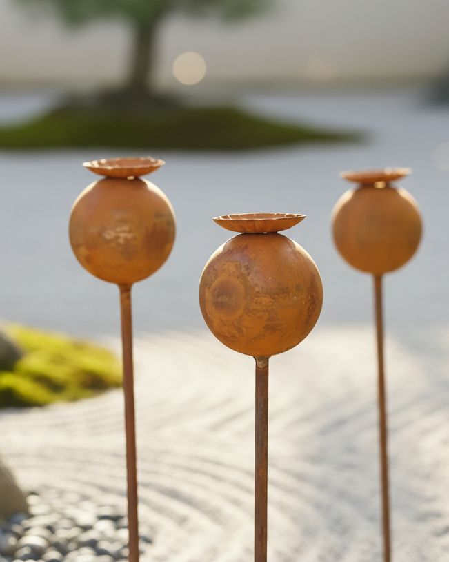 Set of three rusty metal poppy seed head garden stakes for outdoor decor, featuring detailed floral designs by Starlight Express.
