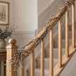 Snowy Twig Garland, snowy twig garland wrapped around a wooden stair rail