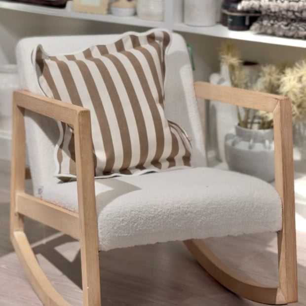 Cream Boucle Sherpa Rocking Chair, cream upholstered rocking chair with a striped cushion in a shop