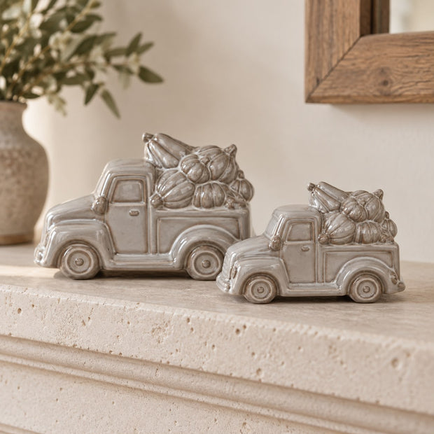 Glazed Neutral Ceramic Truck With Pumpkins, two neutral ceramic pickup trucks carrying pumpkins on a mantel