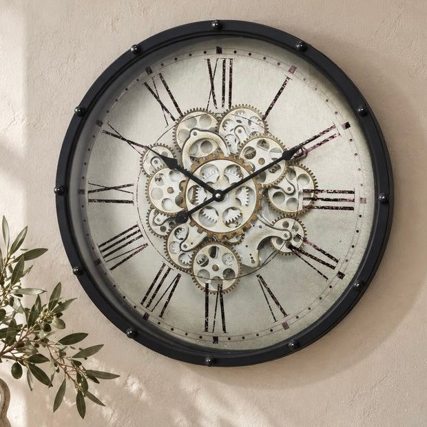 Black Frame Mechanical Skeleton Clock, black-framed skeleton clock with Roman numerals on a cream wall