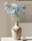 Artificial Ocean Blue Cosmos flower stem from Starlight Express, showcasing vibrant blue petals and green foliage for decorative use.