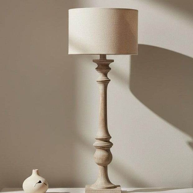Pallido Candlestick Wooden Lamp, tall turned-wood lamp with cream shade on a console