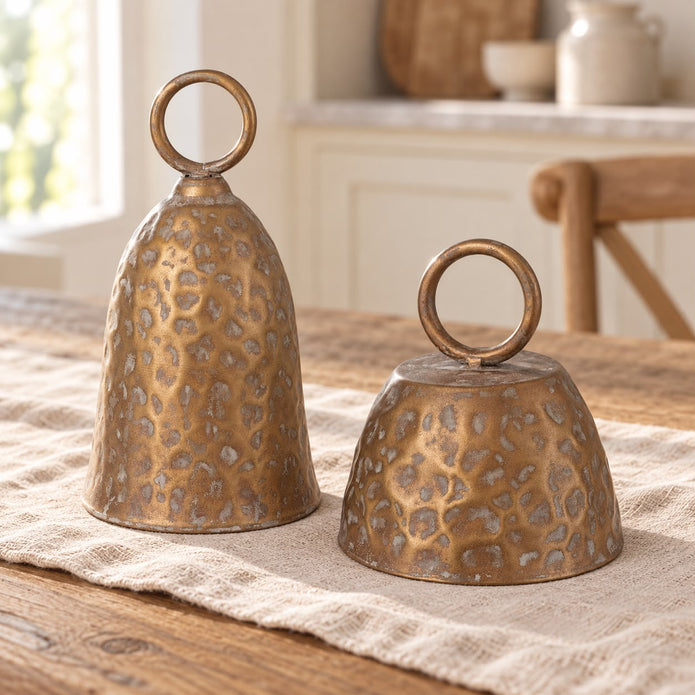Brass Metal Cloche Cow Bell, two brass cloche bells on a light wooden table