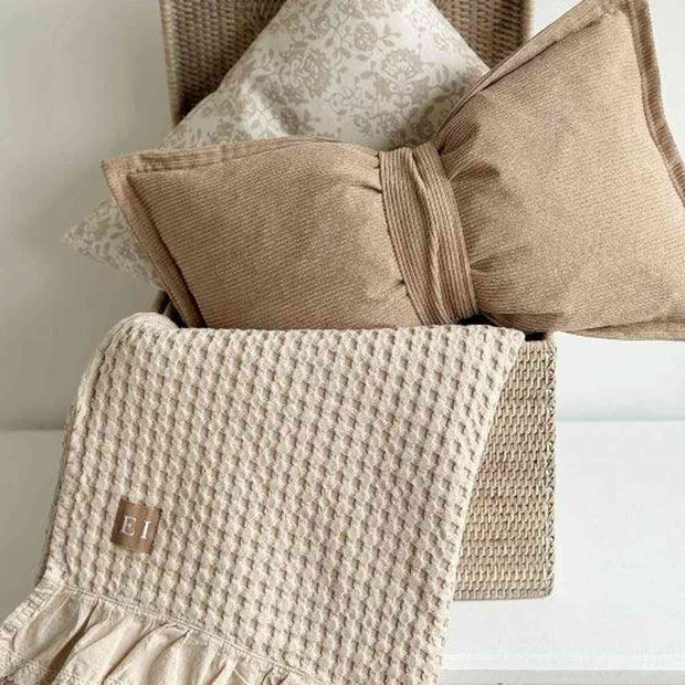 Beige Neutral Corduroy Striped Bow Cushion, beige bow cushion in a woven trunk with cream cushions