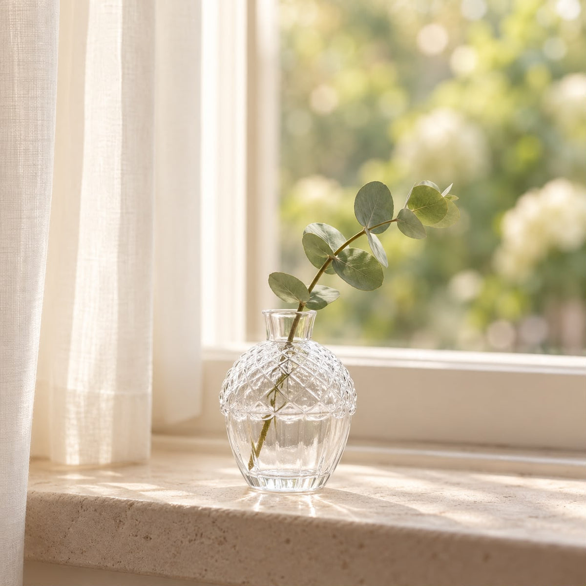 Glass acorn vase with eucalyptus on a windowsill