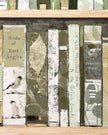Decorative bookshelf with books featuring nature-themed covers on a wooden surface.