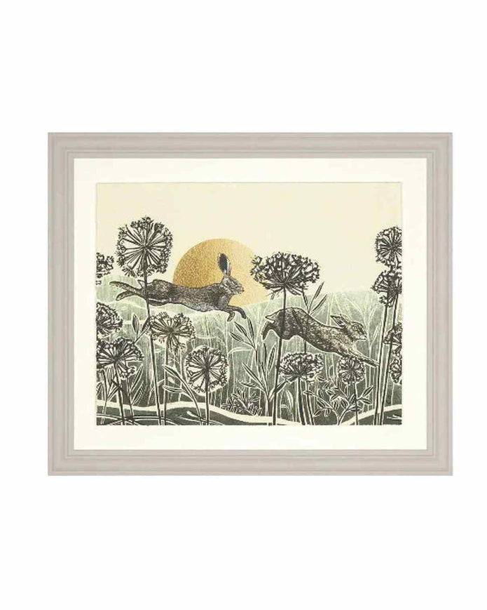 Framed artwork of two deer in a field with a sun in the background