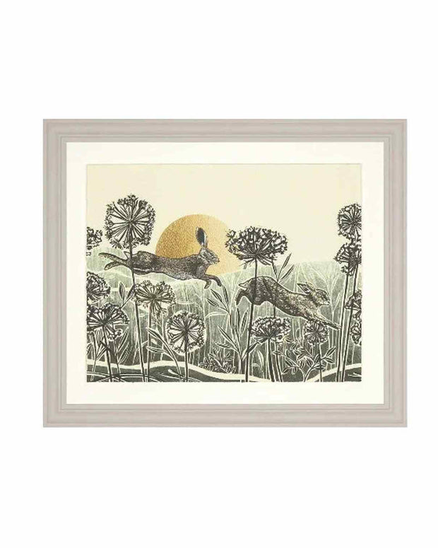 Framed artwork of two deer in a field with a sun in the background