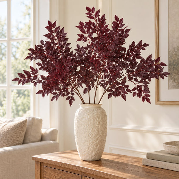 Artificial Burgundy Leaf Foliage Stem, burgundy foliage in a tall cream vase beside a window