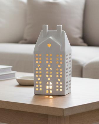 White Ceramic Matt LED Light Up House, tall white ceramic house glowing on a living-room table