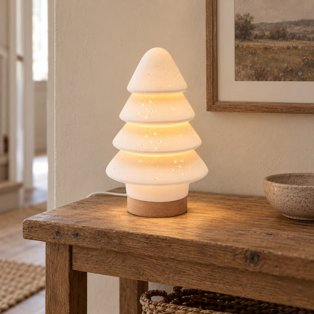 White Porcelain Christmas Tree Tiered Lamp, glowing white tiered tree lamp on a wooden console