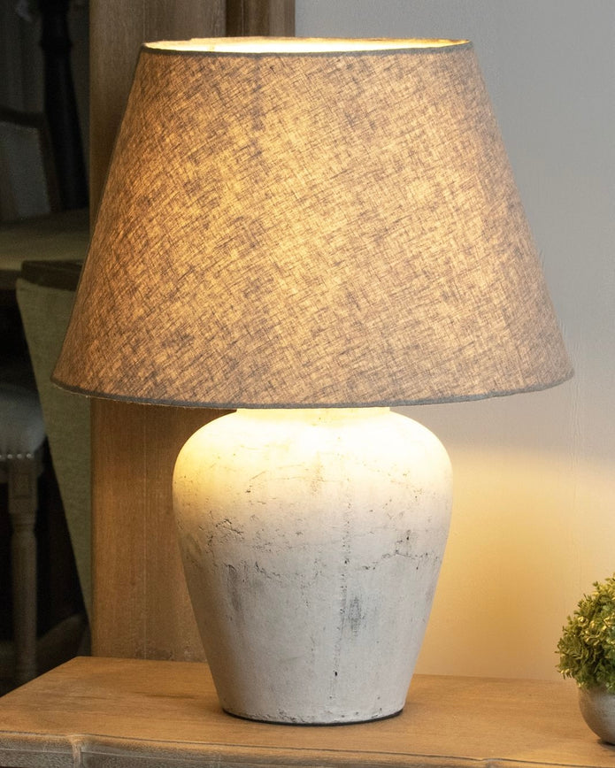 Amesbury medium stone lamp by Hill Interiors, featuring a textured stone base and a classic lampshade for stylish lighting.