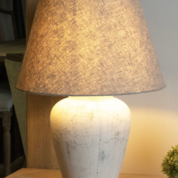 Amesbury medium stone lamp by Hill Interiors, featuring a textured stone base and a classic lampshade for stylish lighting.