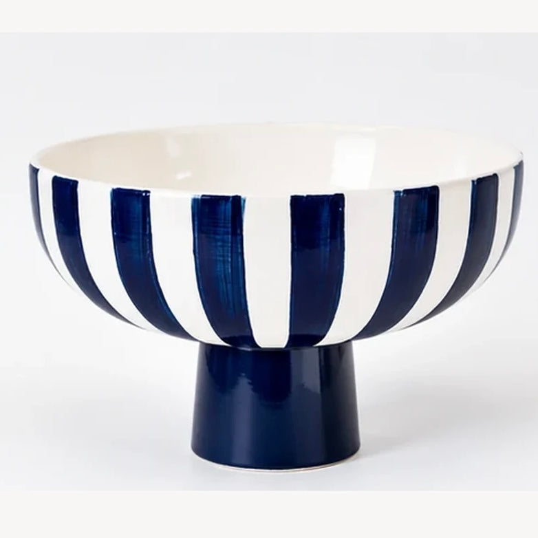 Deep blue and white striped ceramic bowl with a blue pedestal foot on a white background