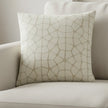 A square throw pillow featuring a textured, raised geometric pattern resembling a stone or reptile skin motif in a light beige and off-white color palette, shown against a plain white background.