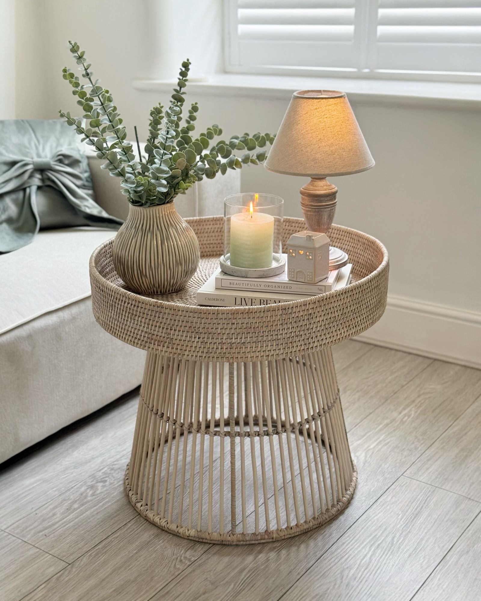 Lows rattan round side table with a natural woven surface and sturdy legs, perfect for living room or bedroom decor.