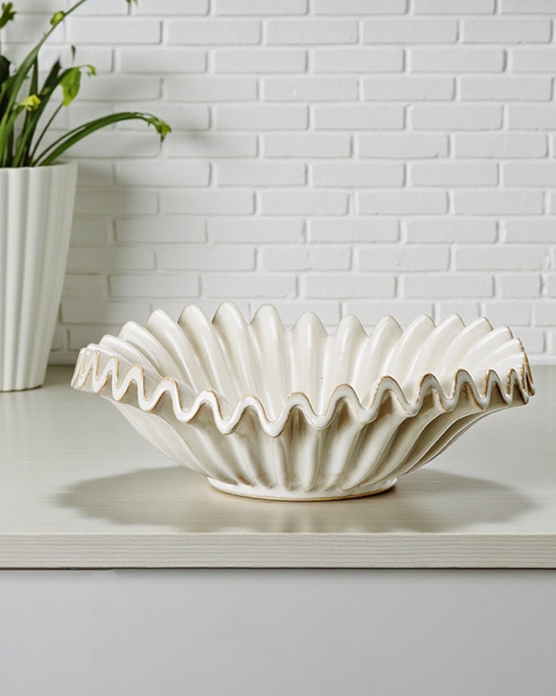 Neutral ceramic glazed ribbed wavy bowl by Wikholmform, designed for modern home décor, with a textured wavy surface.