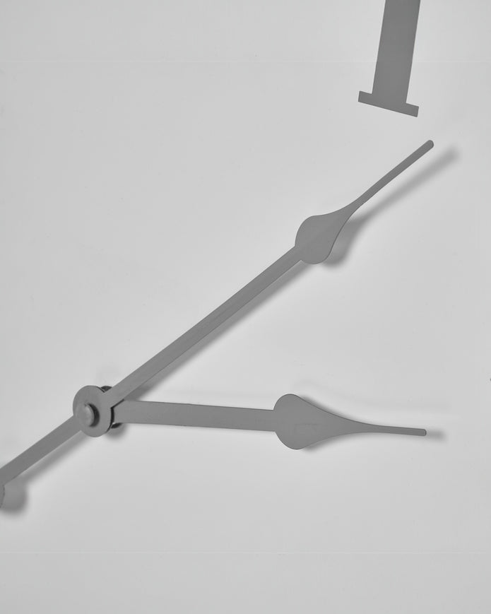White round Aubrey wall clock by Hill Interiors showing a minimalist design with black hour and minute hands.