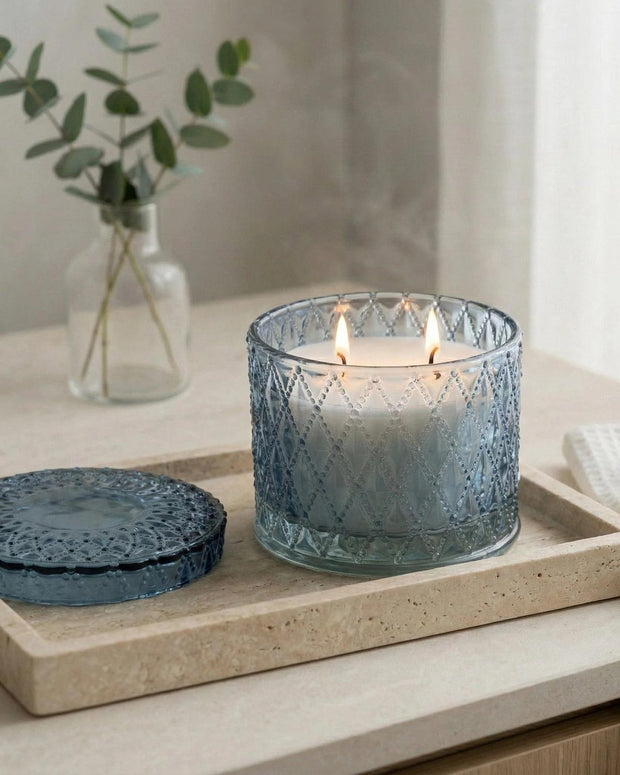 Blue round embossed candle jar from Candlelight Products Ltd, featuring intricate embossed patterns and a smooth round shape.