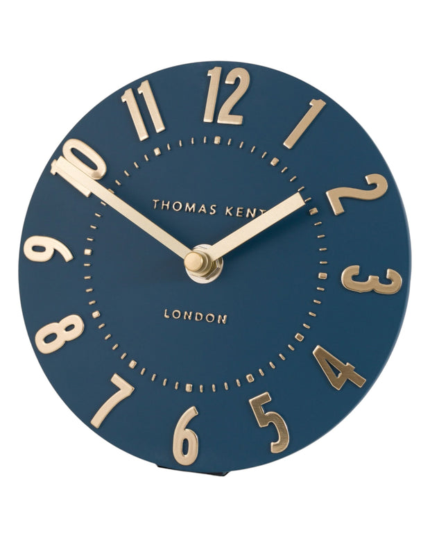 Thomas Kent Mulberry mantle clock in midnight blue with a classic round face and black hands, sitting on a wooden surface.