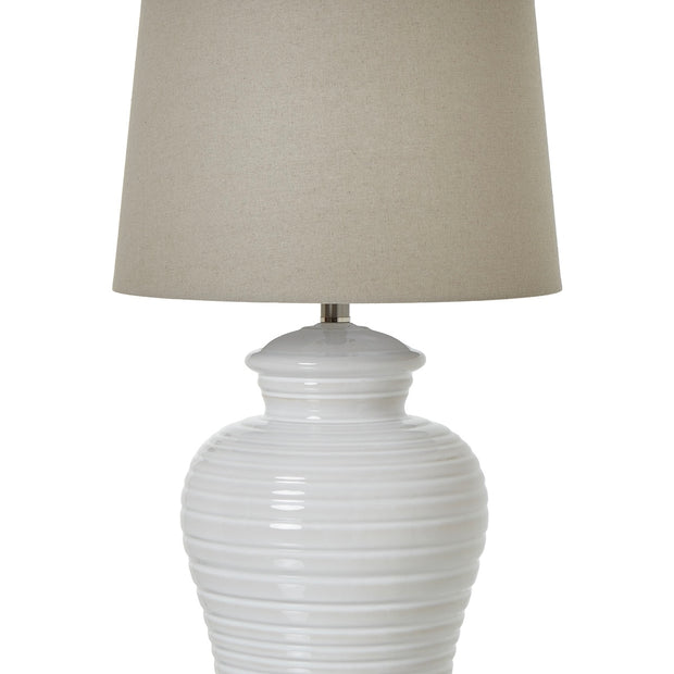White ceramic ribbed urn-style lamp from Hill Interiors, showcasing a sleek, modern lighting fixture with textured surface.