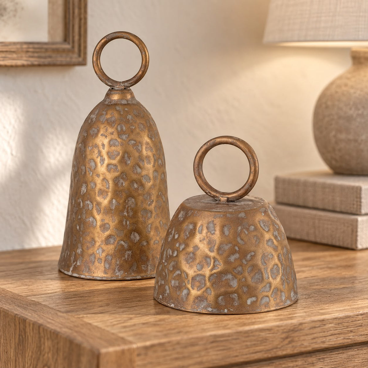 Brass Metal Cloche Cow Bell, two brass cloche bells on a console beside a lamp