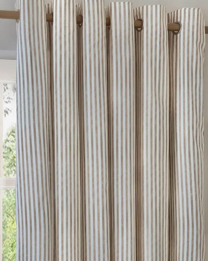 Riva Home yard natural striped blackout eyelet curtains hanging in a room, soft furnishings with black and white stripes.