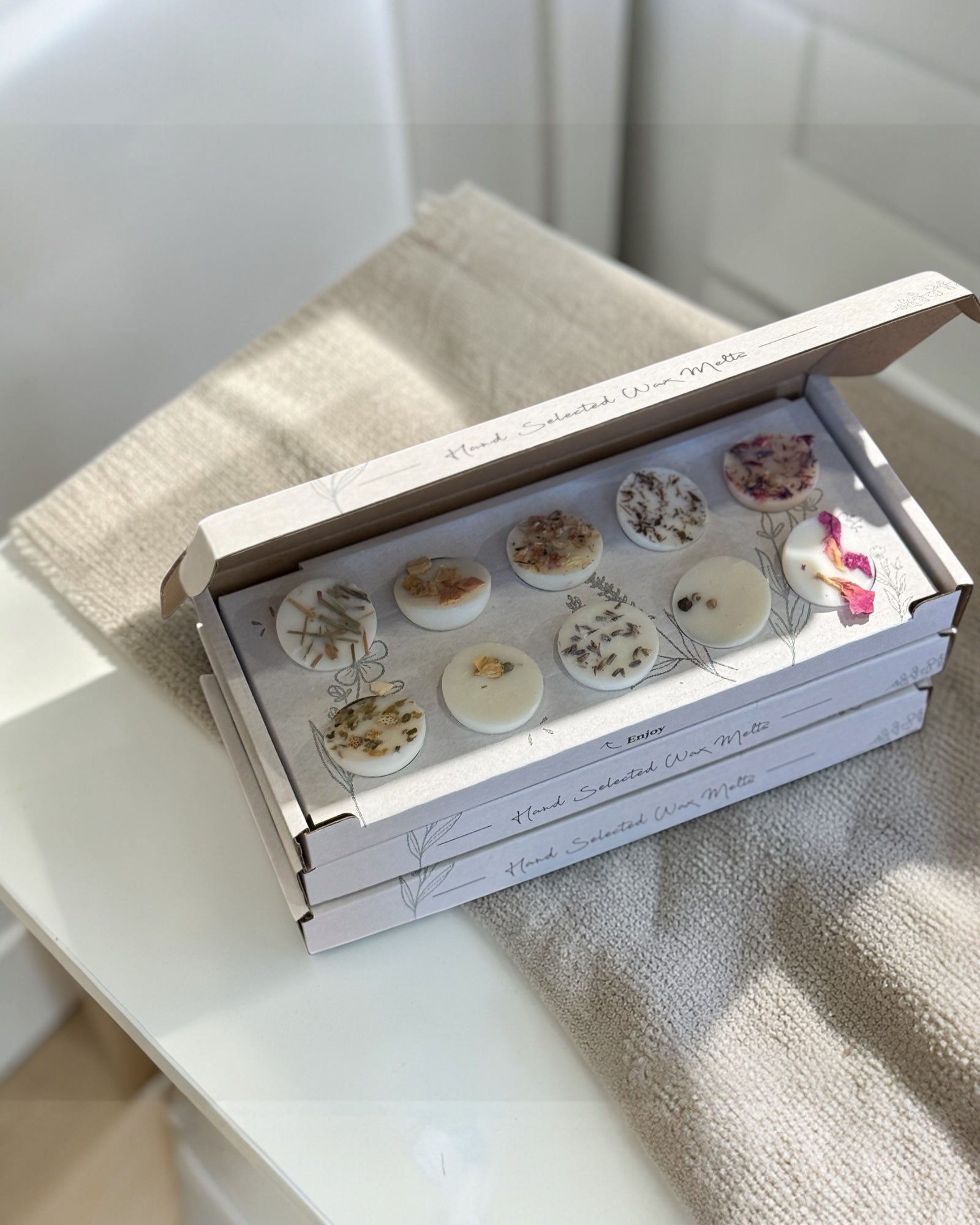 Gift box of ten assorted wax melts from The Candle Brand Ltd, showcasing a variety of colorful wax melt pieces in a decorative box.