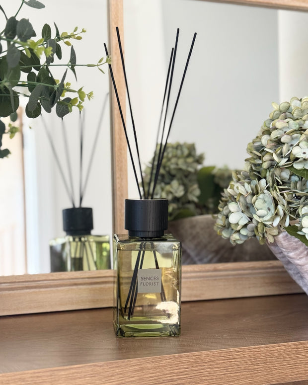 Olive green Coach House large reed diffuser with botanical fragrance, featuring a glass bottle and reed sticks for home scenting.