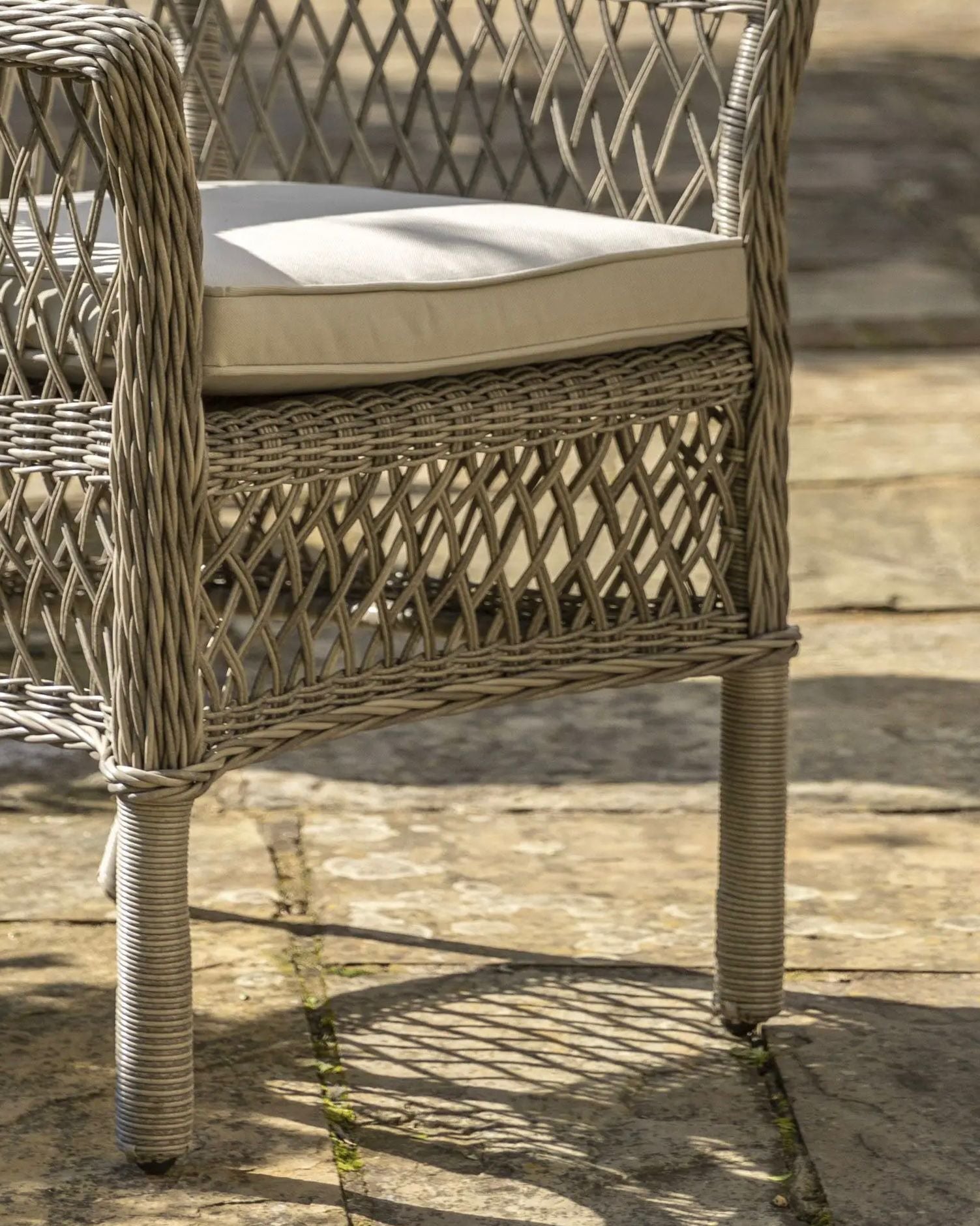 Natural rattan Menton two-seat bistro set for garden by Gallery Direct, featuring woven rattan seats and a matching table.