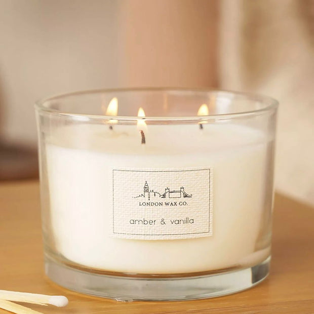 London Wax Company Triple Wick Lidded Candle - Amber & Vanilla, lit three-wick Amber and Vanilla candle in clear glass