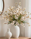 Cream artificial daisy flower stem from Starlight Express, with realistic white petals and green foliage on a slender stem.