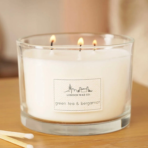 London Wax Company Triple Wick Lidded Candle - Green Tea & Bergamot, lit three-wick Green Tea and Bergamot candle in clear glass
