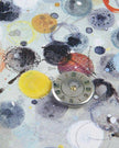 Small clock face on a textured surface with colorful circular patterns