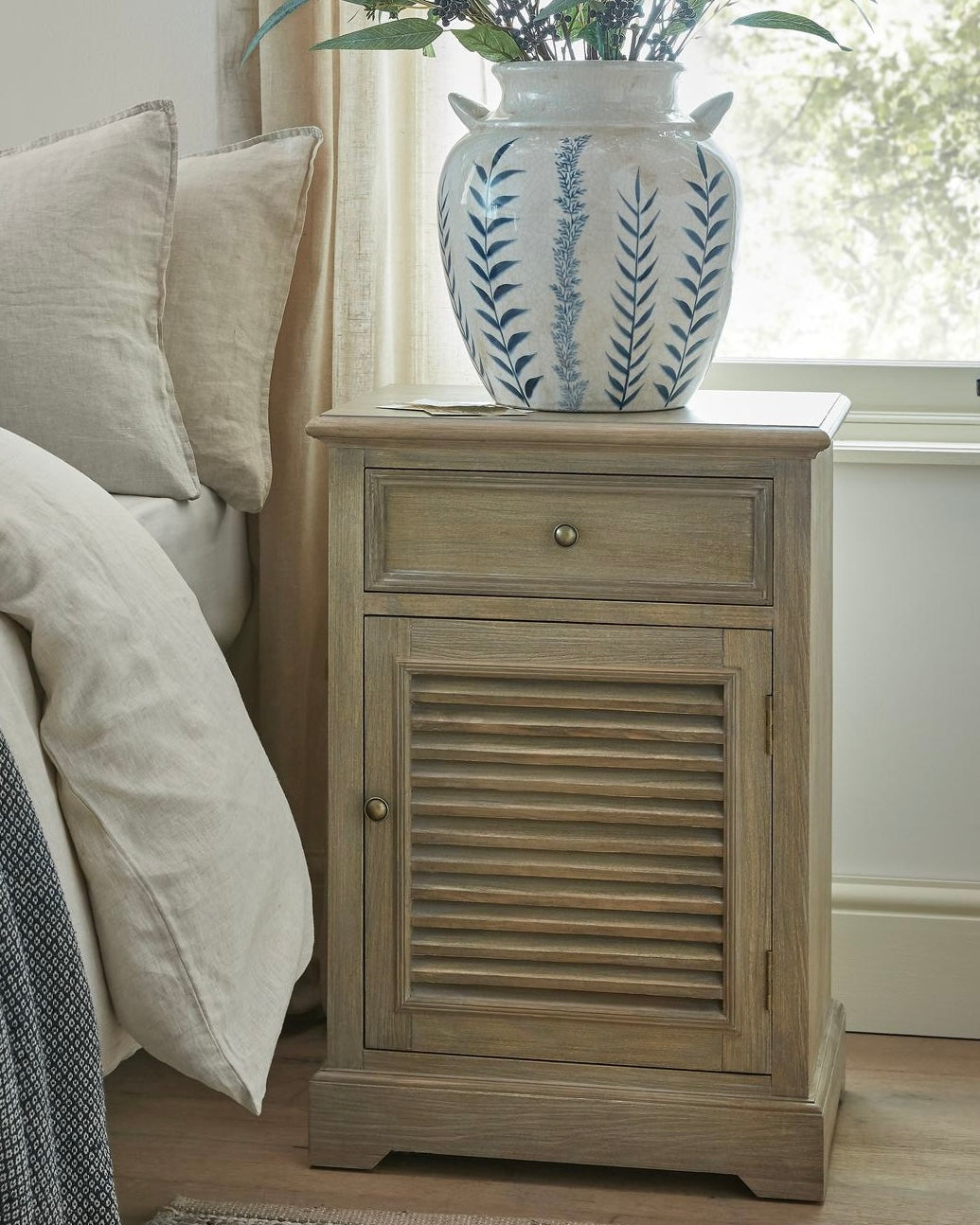 Hill Interiors Delphine Collection bedside table with one drawer and one door, showcasing a sleek wooden finish and modern design.