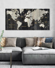 World map canvas on a wall above a gray sofa with decorative pillows.