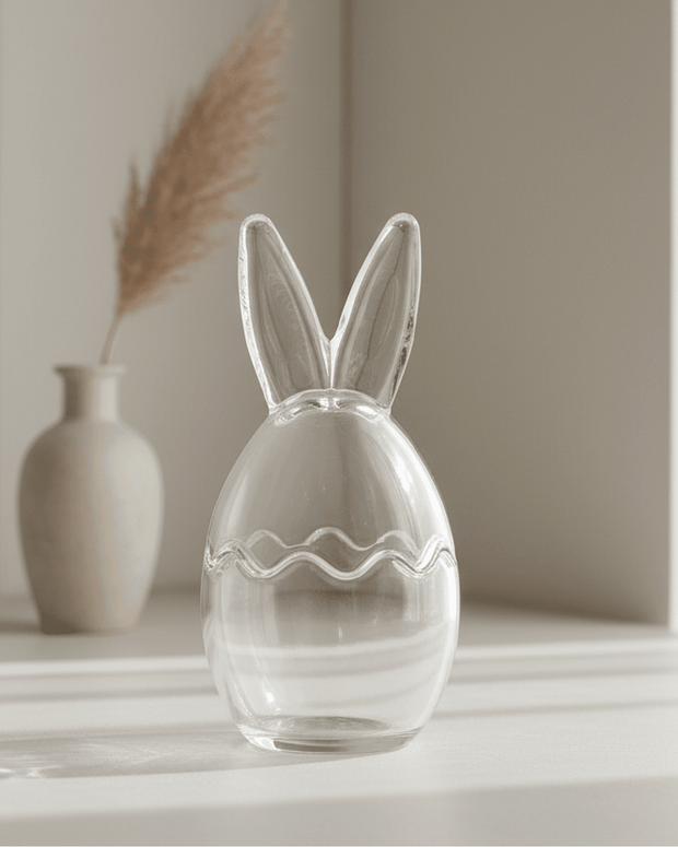 Clear glass vase shaped like a rabbit with a wavy line design on a neutral background