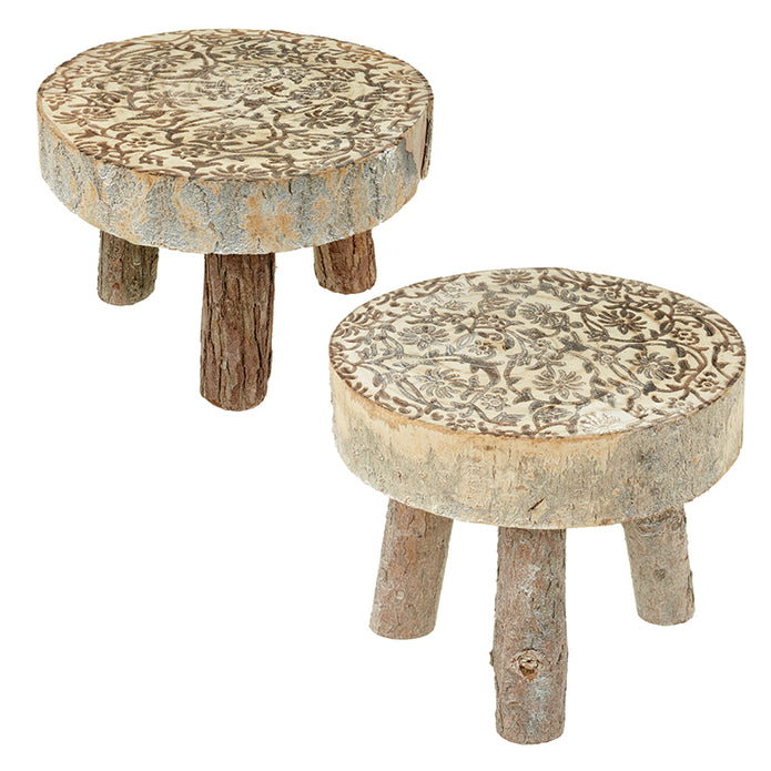 Two rustic wooden stools with round cream and brown patterned tops and short natural branch legs on white.