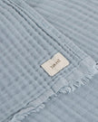 Riva Home ocean blue muslin cotton throw bed cover on a bed, showcasing soft and lightweight bedroom decor.