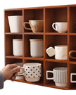 Dark wooden mug display shelf unit for kitchen and dining, showcasing space for coffee mugs and kitchen decor.