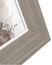 Close-up of a wooden picture frame with a blurred artwork inside