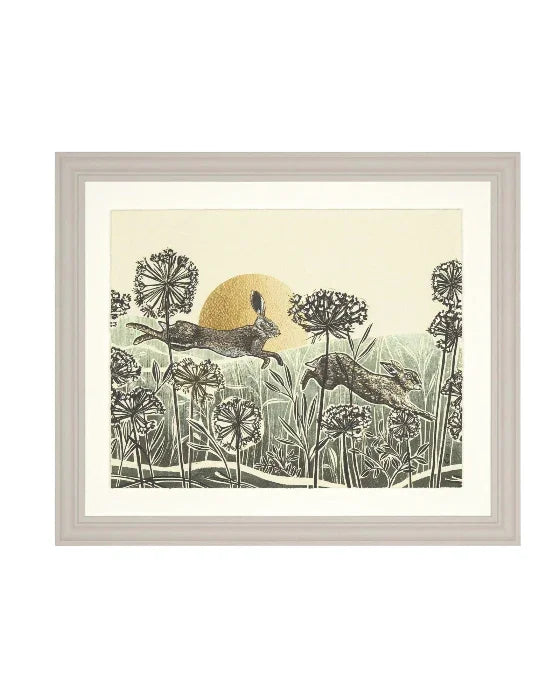 Framed artwork of two deer in a field with a sun in the background